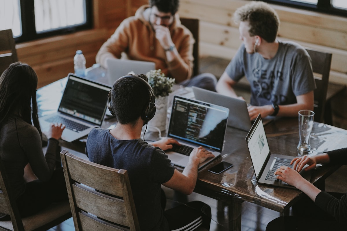 Startup team collaborating around laptops — planning an MVP
