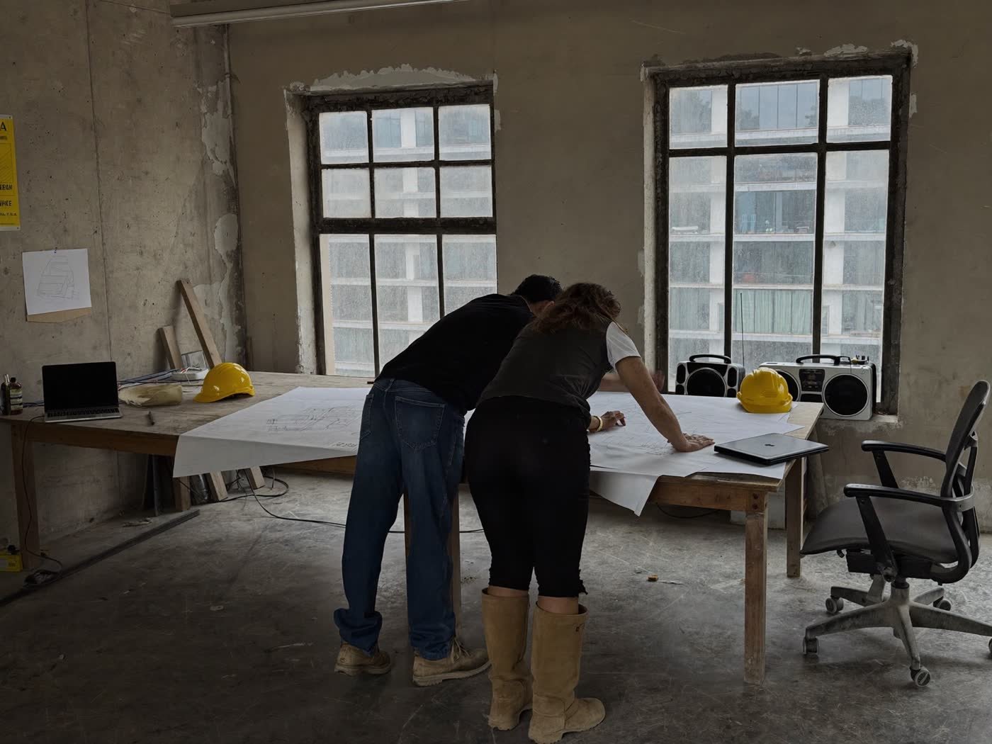 Two people reading drawings in a site office