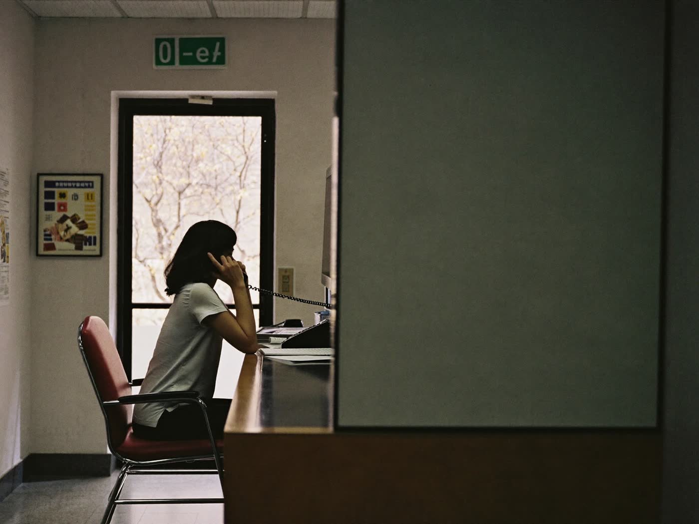 A small office reception, a person on the phone